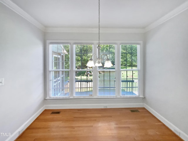 2408 Tiltonshire Ln, Apex, NC 27539 - unfurnished dining area with a chandelier, ornamental molding, and wood finished floors
