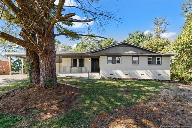 1718 Shiloh Dr, Fayetteville, NC 28304 - view of front facade with crawl space, a porch, a front lawn, and a carport