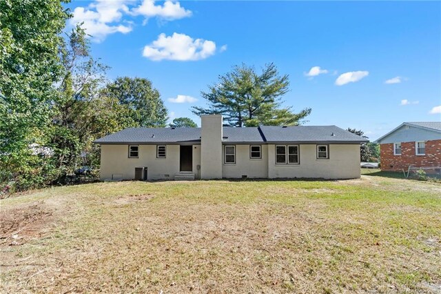 1718 Shiloh Dr, Fayetteville, NC 28304 - back of house featuring a chimney, a yard, and stucco siding