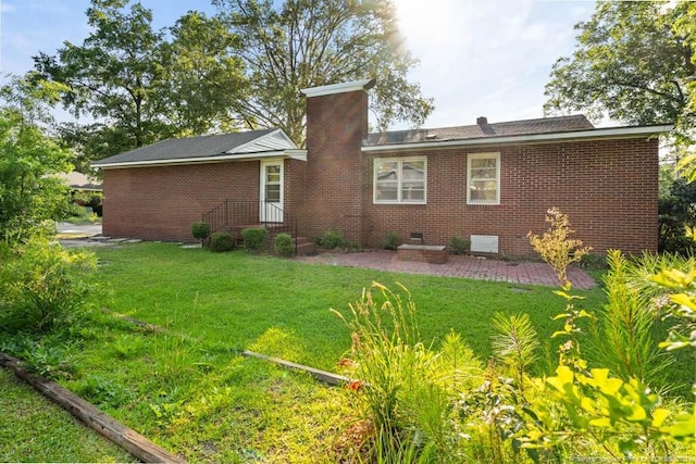 1905 N Rowland Ave N, Lumberton, NC 28358 - rear view of property featuring crawl space, a yard, a chimney, brick siding, and a patio