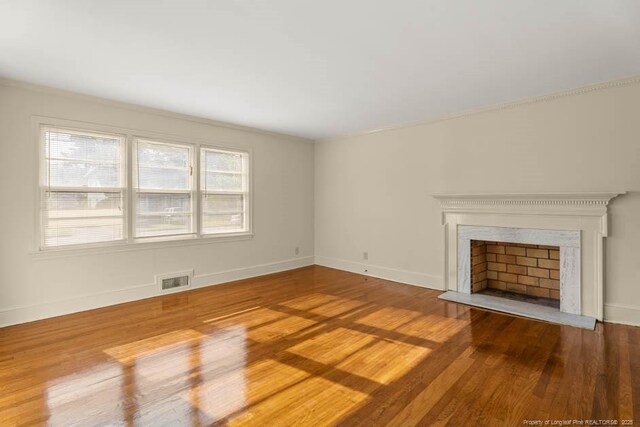 1905 N Rowland Ave N, Lumberton, NC 28358 - unfurnished living room featuring wood finished floors and a fireplace