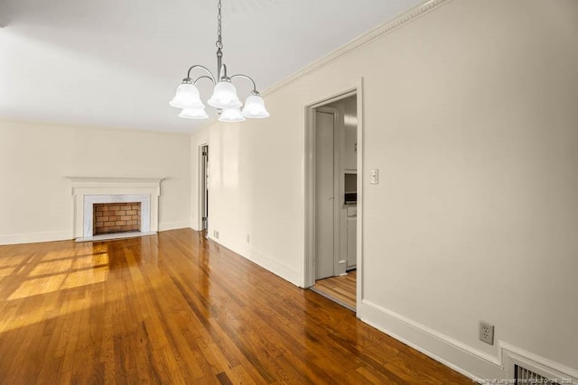 1905 N Rowland Ave N, Lumberton, NC 28358 - unfurnished living room with a chandelier, wood finished floors, and a fireplace with flush hearth