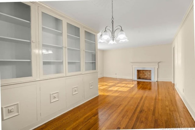 1905 N Rowland Ave N, Lumberton, NC 28358 - unfurnished living room with a chandelier, hardwood / wood-style flooring, and a fireplace with flush hearth