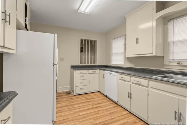 1905 N Rowland Ave N, Lumberton, NC 28358 - kitchen featuring white appliances, light wood-style flooring, dark countertops, and plenty of natural light