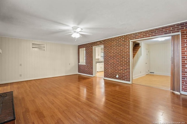 1905 N Rowland Ave N, Lumberton, NC 28358 - spare room with a ceiling fan, wood finished floors, stairway, and brick wall