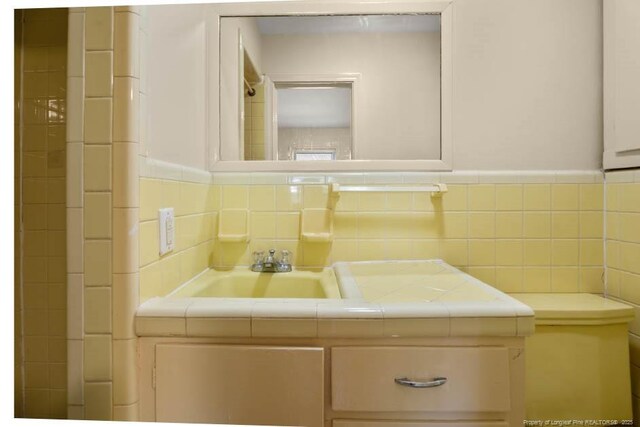 1905 N Rowland Ave N, Lumberton, NC 28358 - bathroom featuring vanity, tile walls, and a wainscoted wall