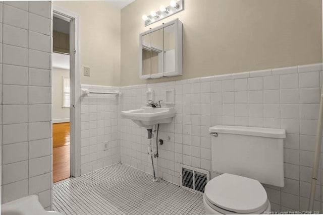 1905 N Rowland Ave N, Lumberton, NC 28358 - bathroom with tile walls, wainscoting, and tile patterned flooring