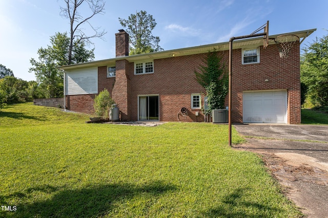 3603 Grimes Ave, Durham, NC 27703 - rear view of house with asphalt driveway, a chimney, a garage, brick siding, and a yard