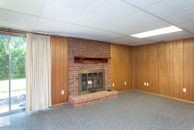 3603 Grimes Ave, Durham, NC 27703 - unfurnished living room with wooden walls, a brick fireplace, carpet, and a paneled ceiling