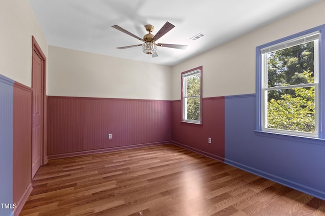 3421 Tunas St, Raleigh, NC 27616 - spare room featuring wainscoting, wood finished floors, and a ceiling fan