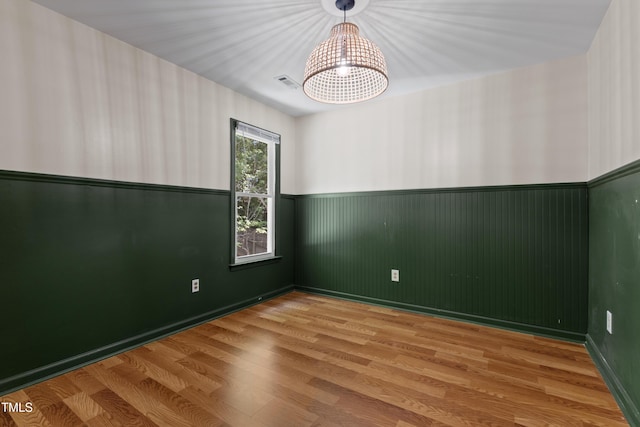 3421 Tunas St, Raleigh, NC 27616 - unfurnished room featuring a chandelier, a wainscoted wall, and wood finished floors