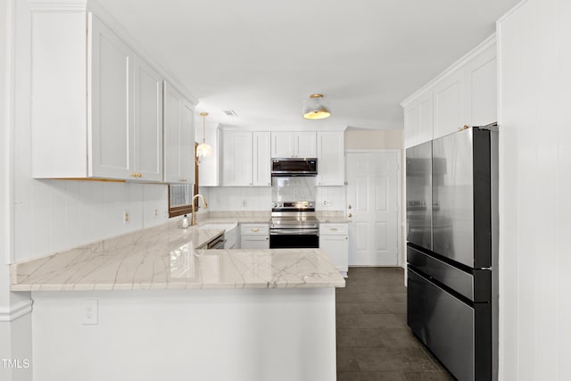 3421 Tunas St, Raleigh, NC 27616 - kitchen with stainless steel appliances, a peninsula, white cabinetry, backsplash, and dark tile patterned floors