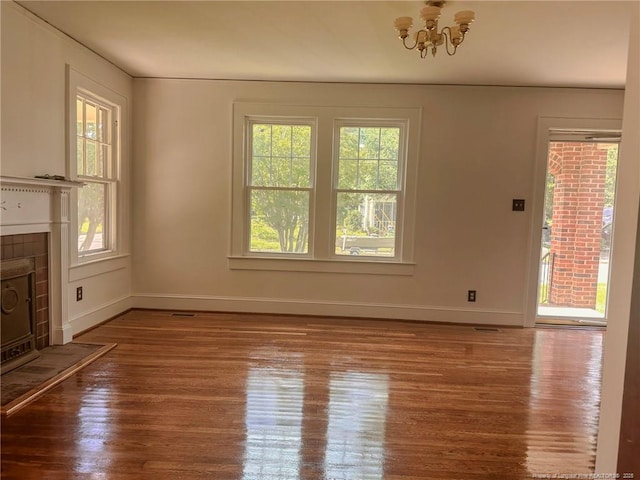202 E 17th St, Lumberton, NC 28358 - unfurnished living room with healthy amount of natural light, a tile fireplace, wood finished floors, and a chandelier