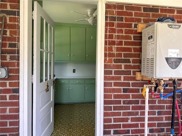 202 E 17th St, Lumberton, NC 28358 - kitchen with green cabinets, water heater, brick wall, tile patterned floors, and a ceiling fan