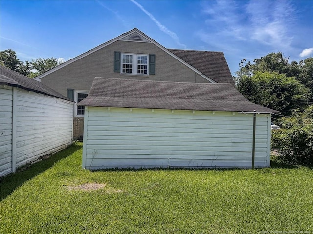 202 E 17th St, Lumberton, NC 28358 - view of property exterior featuring a lawn, an outdoor structure, and a shingled roof