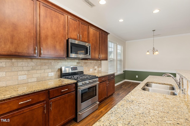 713 Summer Music Ln, Raleigh, NC 27603 - kitchen with stainless steel appliances, dark wood finished floors, crown molding, tasteful backsplash, and light stone countertops