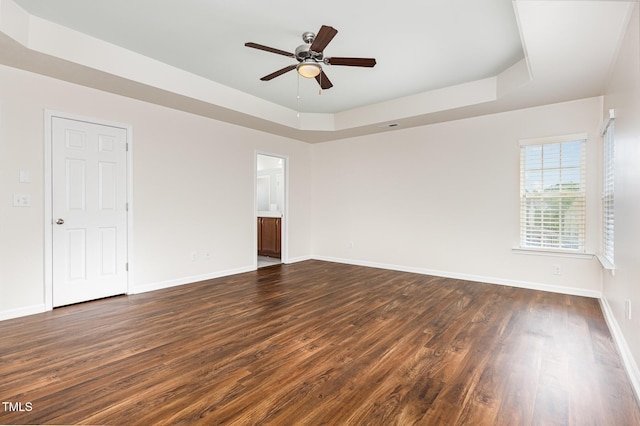 713 Summer Music Ln, Raleigh, NC 27603 - spare room featuring a tray ceiling, dark wood-style flooring, and a ceiling fan
