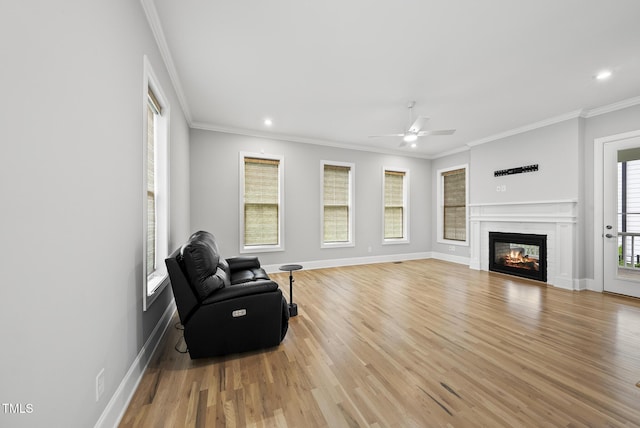 733 Daniel Ridge Rd, Wendell, NC 27591 - living area featuring light wood-type flooring, ceiling fan, a glass covered fireplace, ornamental molding, and recessed lighting