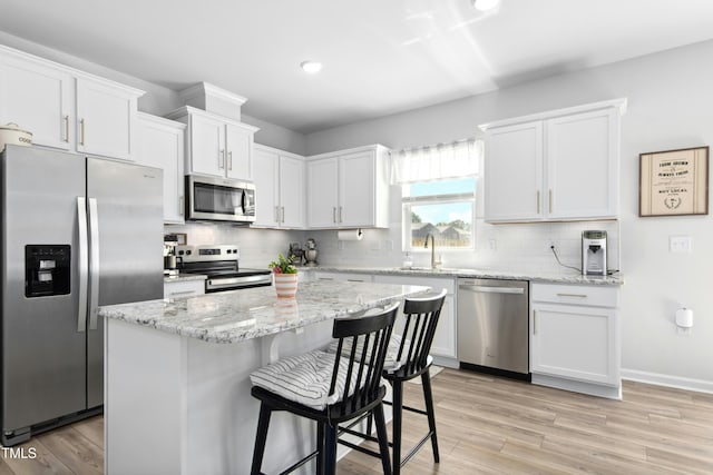 444 Campbell Ridge Pl, Wendell, NC 27591 - kitchen featuring stainless steel appliances, white cabinets, decorative backsplash, light wood finished floors, and recessed lighting