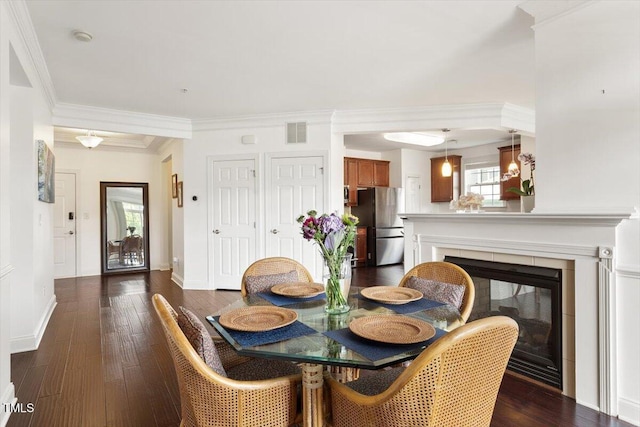 10511 Rosegate Ct Unit 103, Raleigh, NC 27617 - dining room with dark wood-style floors, a glass covered fireplace, and crown molding