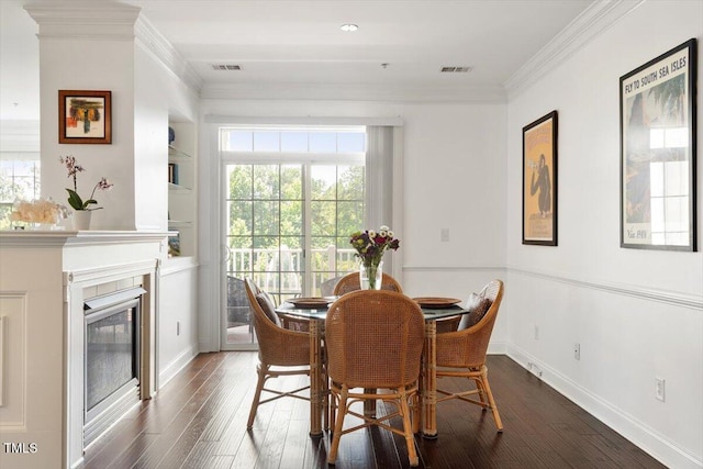 10511 Rosegate Ct Unit 103, Raleigh, NC 27617 - dining room with dark wood-style floors, ornamental molding, and a glass covered fireplace