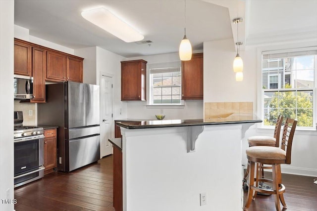 10511 Rosegate Ct Unit 103, Raleigh, NC 27617 - kitchen featuring appliances with stainless steel finishes, decorative backsplash, and dark countertops
