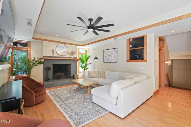 1209 Ravens Point Cir, Raleigh, NC 27614 - living room featuring a tray ceiling, a ceiling fan, wood finished floors, a fireplace, and recessed lighting