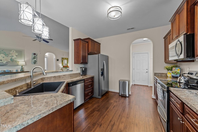 16 Woodglen Dr, Clayton, NC 27527 - kitchen with appliances with stainless steel finishes, arched walkways, a ceiling fan, dark wood finished floors, and decorative light fixtures