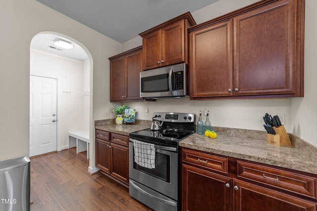 16 Woodglen Dr, Clayton, NC 27527 - kitchen featuring appliances with stainless steel finishes, arched walkways, and dark wood finished floors