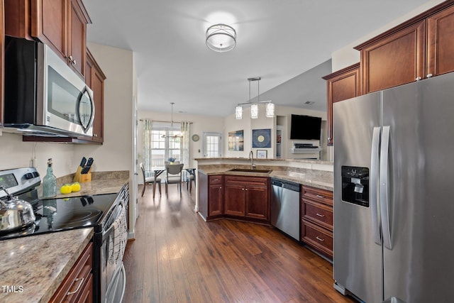 16 Woodglen Dr, Clayton, NC 27527 - kitchen featuring appliances with stainless steel finishes, a peninsula, dark wood-type flooring, light stone countertops, and pendant lighting