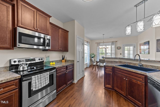 16 Woodglen Dr, Clayton, NC 27527 - kitchen with stainless steel appliances, dark wood-style floors, a chandelier, and pendant lighting