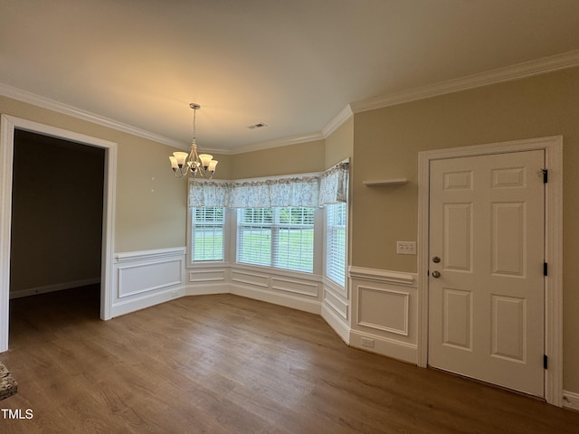 3005 Condor Ct, Deep Run, NC 28525 - unfurnished dining area featuring a chandelier, wood finished floors, crown molding, a wainscoted wall, and a decorative wall