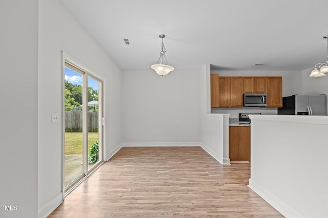 4716 Miller Dr, Durham, NC 27704 - kitchen with appliances with stainless steel finishes, brown cabinetry, light wood-style flooring, pendant lighting, and light countertops
