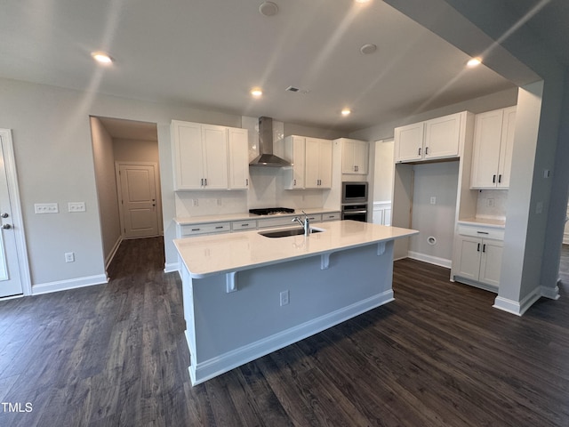 3509 Bailey Lake Dr, Fuquay Varina, NC 27526 - kitchen featuring wall chimney range hood, white cabinets, dark wood-style floors, appliances with stainless steel finishes, and light countertops