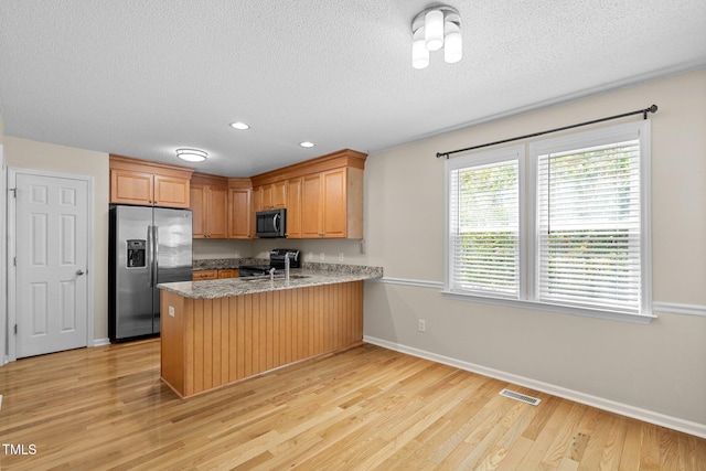 276 Sagamore Dr, Louisburg, NC 27549 - kitchen featuring stainless steel refrigerator with ice dispenser, black range with electric stovetop, a peninsula, light wood-style floors, and a textured ceiling