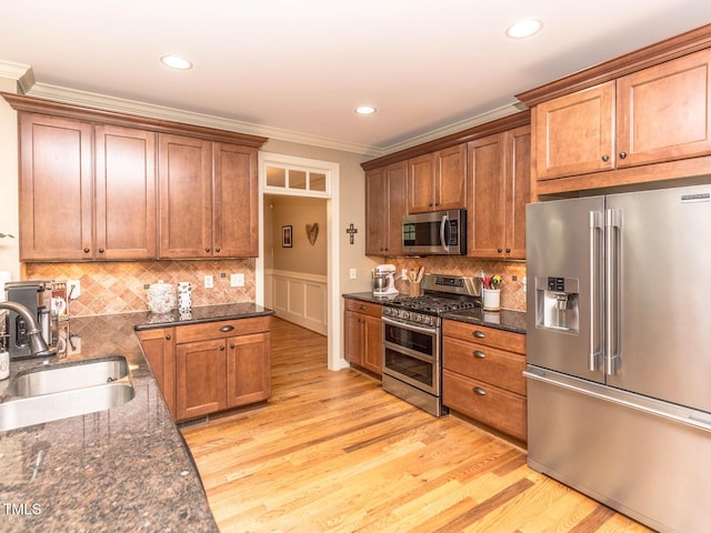 30 Cole Creek Way, Franklinton, NC 27525 - kitchen with stainless steel appliances, ornamental molding, light wood-style floors, brown cabinets, and recessed lighting