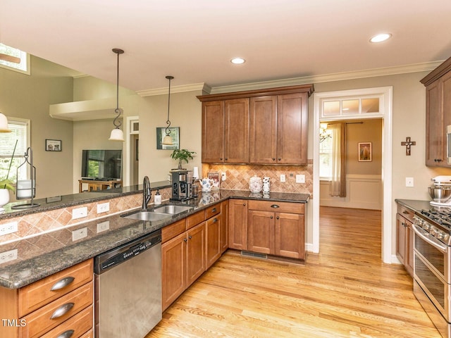 30 Cole Creek Way, Franklinton, NC 27525 - kitchen with stainless steel appliances, light wood-style flooring, brown cabinets, decorative light fixtures, and crown molding