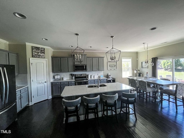 192 Waterpine Dr, Garner, NC 27529 - kitchen with stainless steel appliances, crown molding, gray cabinets, dark wood-style flooring, and a kitchen bar