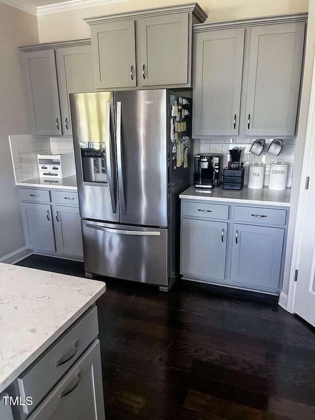 192 Waterpine Dr, Garner, NC 27529 - kitchen with stainless steel fridge, gray cabinetry, dark wood finished floors, ornamental molding, and light stone countertops