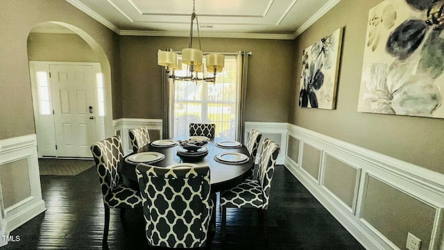 192 Waterpine Dr, Garner, NC 27529 - dining room featuring dark wood-style floors, a chandelier, crown molding, arched walkways, and a decorative wall