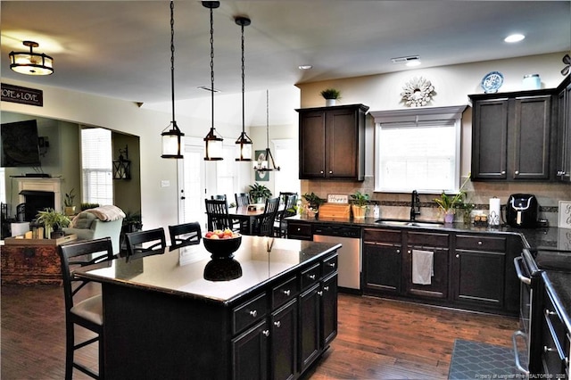 930 Old Vander Rd, Fayetteville, NC 28312 - kitchen featuring appliances with stainless steel finishes, a kitchen bar, open floor plan, decorative backsplash, and a fireplace
