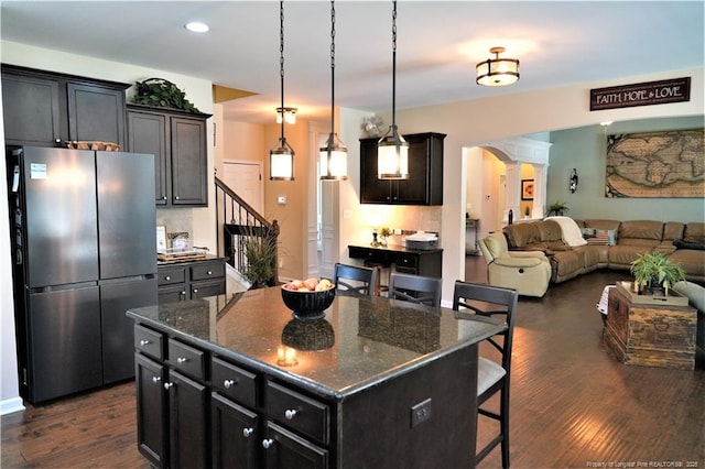 930 Old Vander Rd, Fayetteville, NC 28312 - kitchen featuring freestanding refrigerator, a breakfast bar area, open floor plan, dark wood finished floors, and dark stone countertops