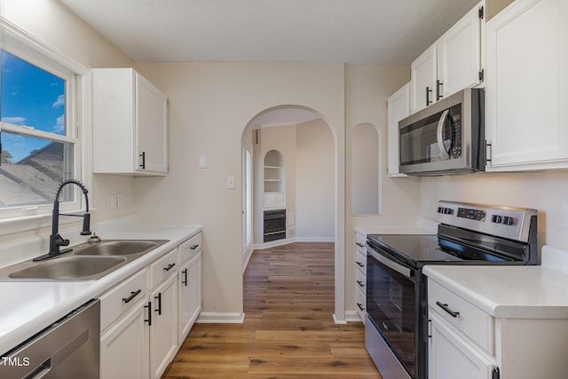 61 Fashion Pl, Durham, NC 27705 - kitchen featuring stainless steel appliances, light wood finished floors, heating unit, white cabinets, and light countertops