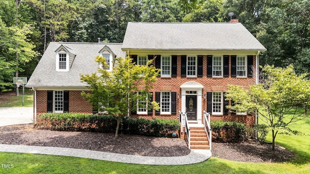 10721 Marabou Ct, Raleigh, NC 27614 - view of front of home with brick siding, a front lawn, view of wooded area, and a chimney