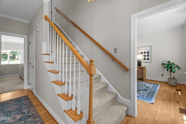 10721 Marabou Ct, Raleigh, NC 27614 - stairway with wood finished floors, crown molding, and a chandelier