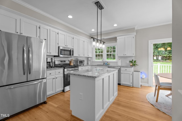 10721 Marabou Ct, Raleigh, NC 27614 - kitchen featuring stainless steel appliances, ornamental molding, white cabinets, decorative light fixtures, and a kitchen island
