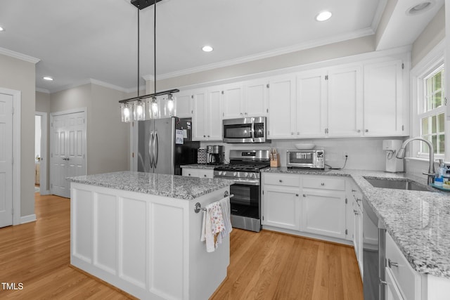 10721 Marabou Ct, Raleigh, NC 27614 - kitchen featuring appliances with stainless steel finishes, a kitchen island, white cabinets, light wood-type flooring, and recessed lighting