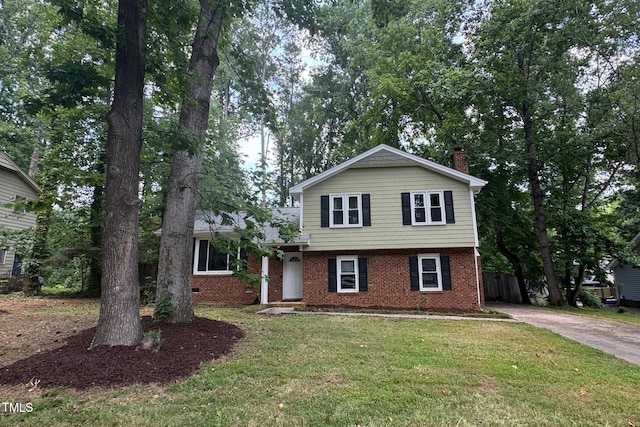 609 Sloan Dr, Cary, NC 27511 - tri-level home featuring brick siding, a front yard, a chimney, and concrete driveway