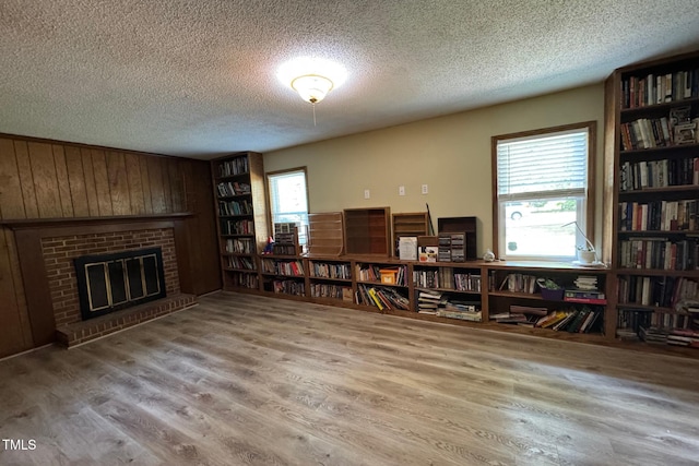 609 Sloan Dr, Cary, NC 27511 - living room featuring a textured ceiling, wood finished floors, plenty of natural light, a fireplace, and wood walls