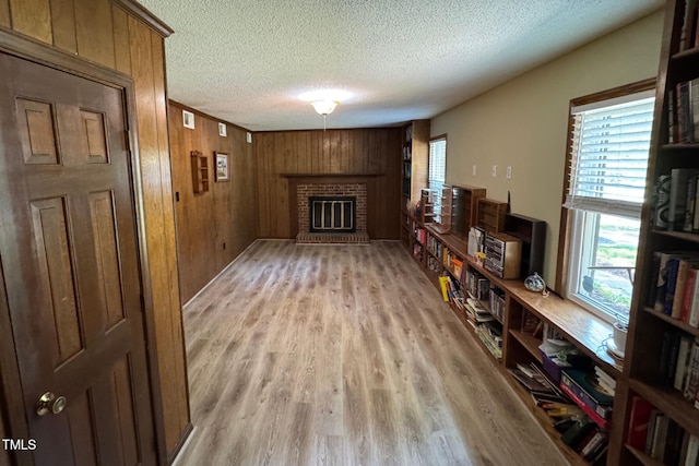 609 Sloan Dr, Cary, NC 27511 - living area featuring a textured ceiling, light wood-style floors, a fireplace, and wooden walls